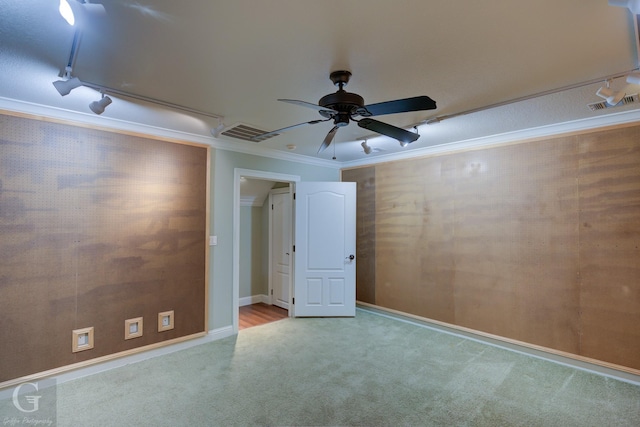 spare room with ornamental molding, ceiling fan, and light carpet