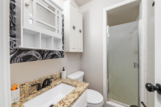 bathroom with toilet, a shower with door, and vanity