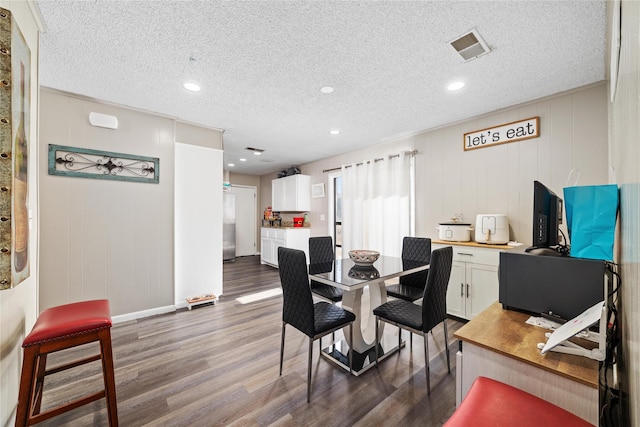 dining space featuring a textured ceiling and dark hardwood / wood-style floors