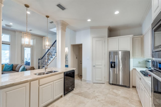 kitchen with sink, white cabinetry, light stone countertops, a notable chandelier, and appliances with stainless steel finishes