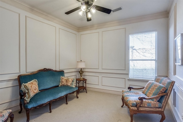 sitting room featuring ornamental molding, ceiling fan, a healthy amount of sunlight, and light carpet