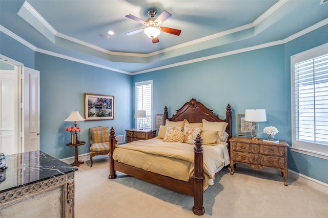 bedroom featuring ceiling fan, a tray ceiling, and ornamental molding