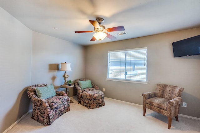 sitting room with ceiling fan and carpet