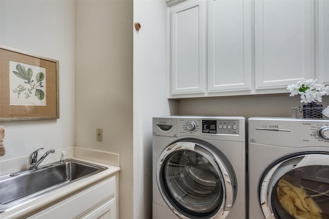 laundry area featuring sink, washing machine and dryer, and cabinets