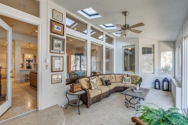 sunroom / solarium with ceiling fan and vaulted ceiling with skylight