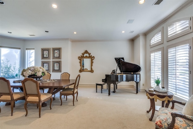 carpeted dining room featuring a healthy amount of sunlight and ornamental molding