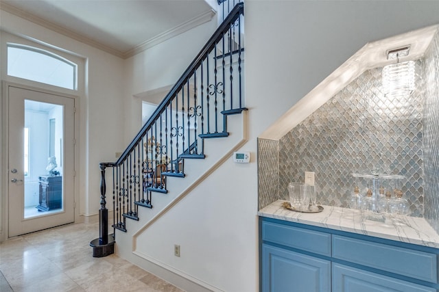 stairs with bar area and crown molding