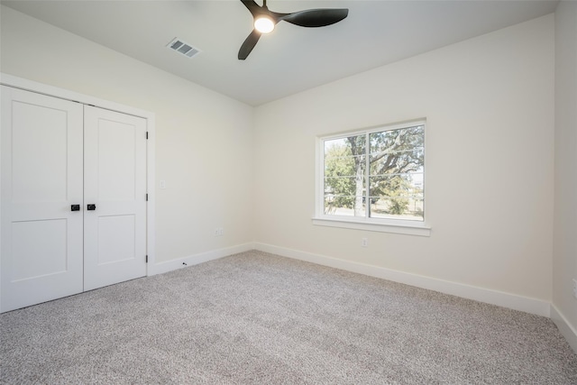 unfurnished bedroom featuring ceiling fan, a closet, and carpet flooring