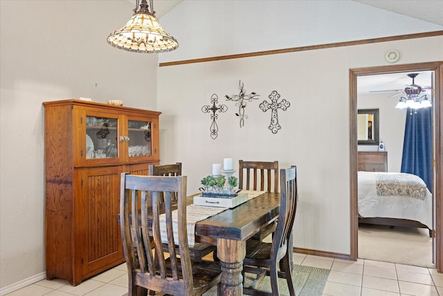 tiled dining room featuring lofted ceiling, ceiling fan, and crown molding