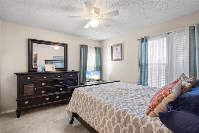 carpeted bedroom featuring ceiling fan and a textured ceiling