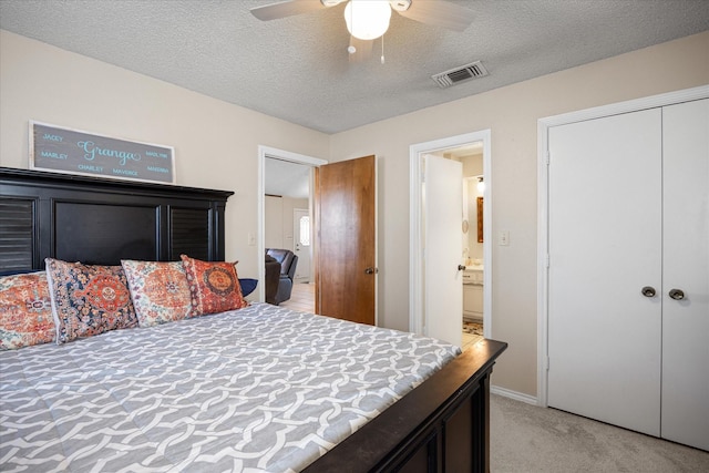 bedroom featuring a textured ceiling, ceiling fan, and light carpet