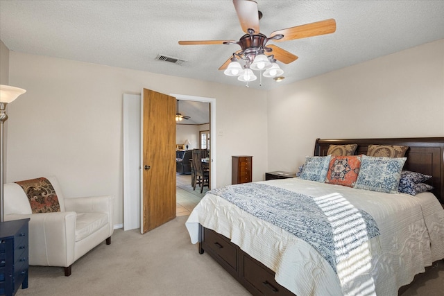 carpeted bedroom with a textured ceiling and ceiling fan