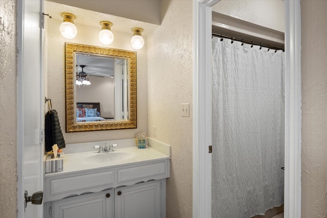 bathroom featuring curtained shower, ceiling fan, and vanity