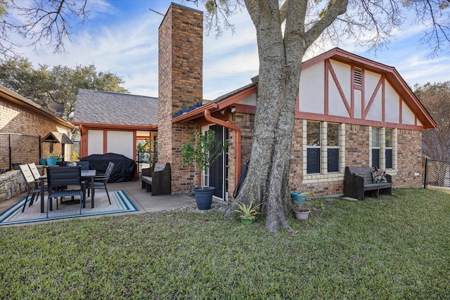 back of house with a patio area and a lawn