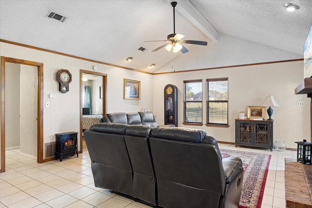 living room with a textured ceiling, lofted ceiling with beams, light tile patterned floors, and a wood stove