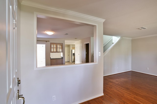 interior space featuring wood-type flooring and crown molding