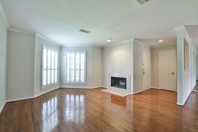 unfurnished living room featuring crown molding, a fireplace, and wood-type flooring