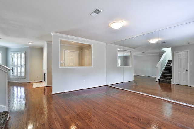 empty room with dark hardwood / wood-style flooring and crown molding