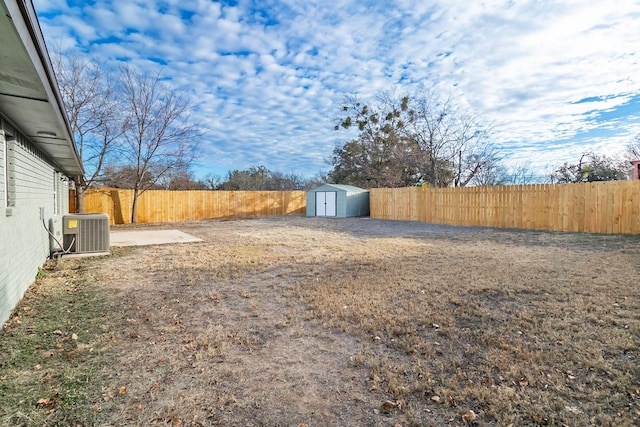 view of yard featuring central AC and a storage shed