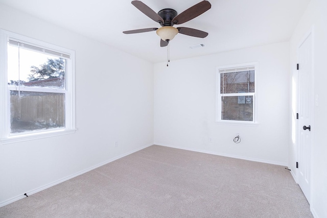 empty room with ceiling fan and light carpet