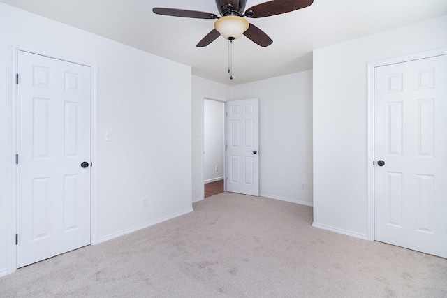 unfurnished bedroom featuring light colored carpet and ceiling fan