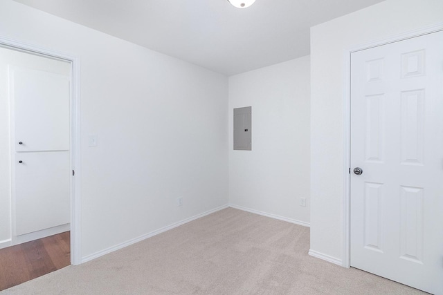 spare room with electric panel and light colored carpet