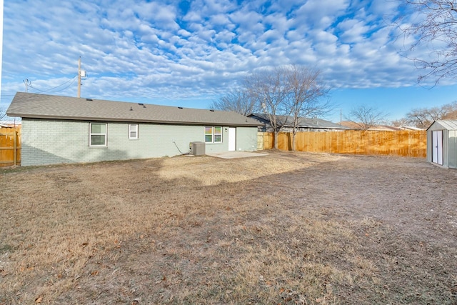 rear view of house with central AC unit, a storage shed, and a patio