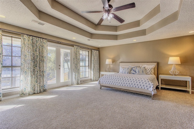 carpeted bedroom with access to outside, a textured ceiling, a raised ceiling, french doors, and ceiling fan