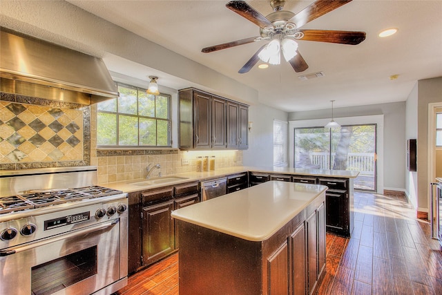 kitchen featuring pendant lighting, stainless steel appliances, tasteful backsplash, a kitchen island, and sink