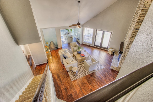 living room with ceiling fan, hardwood / wood-style floors, and high vaulted ceiling