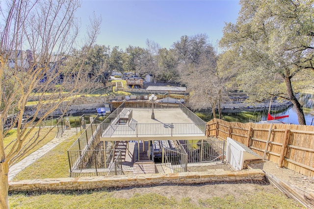 back of house featuring a deck with water view and a yard