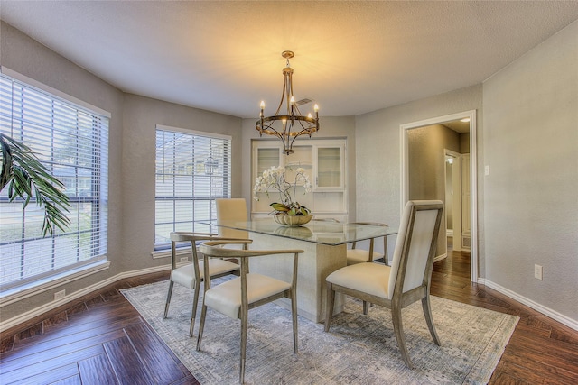 dining room featuring a notable chandelier and dark parquet floors