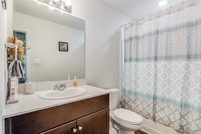 full bathroom with toilet, shower / bath combo with shower curtain, and vanity