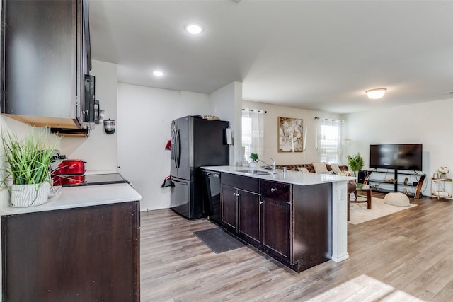 kitchen with black appliances, light hardwood / wood-style flooring, dark brown cabinets, and sink