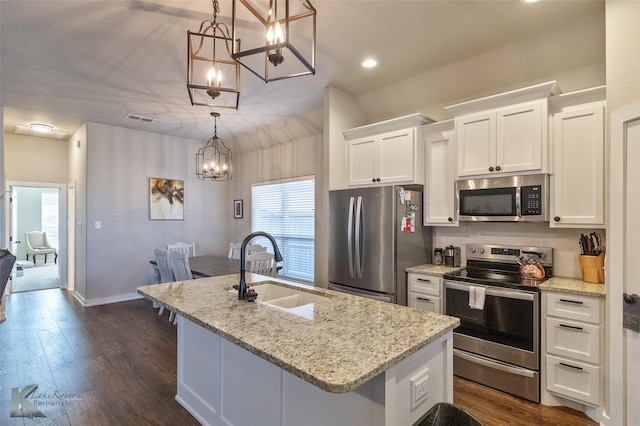 kitchen with a center island with sink, appliances with stainless steel finishes, white cabinets, decorative light fixtures, and sink