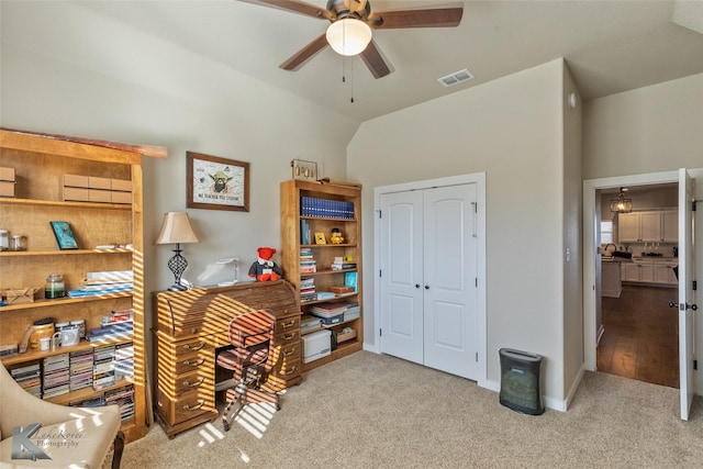 carpeted office space featuring ceiling fan and vaulted ceiling