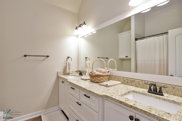 bathroom with curtained shower and vanity