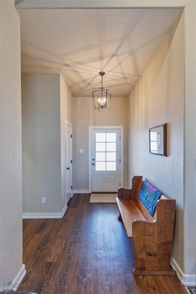 entryway with an inviting chandelier and dark hardwood / wood-style floors