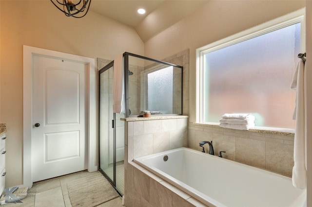 bathroom with lofted ceiling, tile patterned flooring, separate shower and tub, and a wealth of natural light