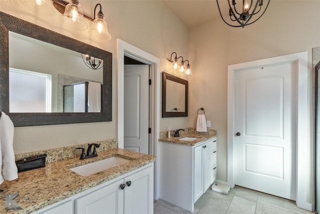 bathroom with a shower with door, vanity, an inviting chandelier, and tile patterned floors