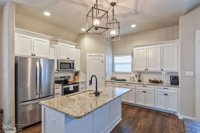 kitchen with appliances with stainless steel finishes, an island with sink, white cabinets, and sink