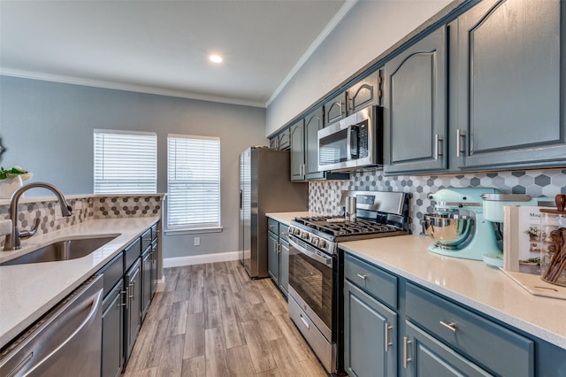 kitchen featuring sink, stainless steel appliances, crown molding, and tasteful backsplash