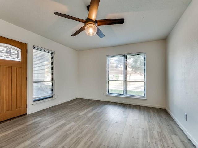 spare room with light wood-type flooring and ceiling fan