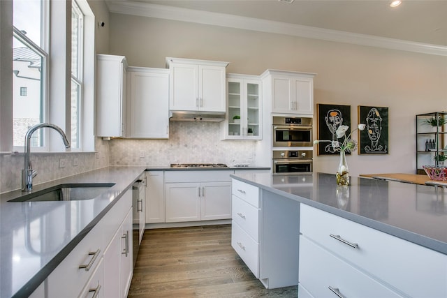 kitchen with sink, stainless steel appliances, white cabinetry, and light wood-type flooring