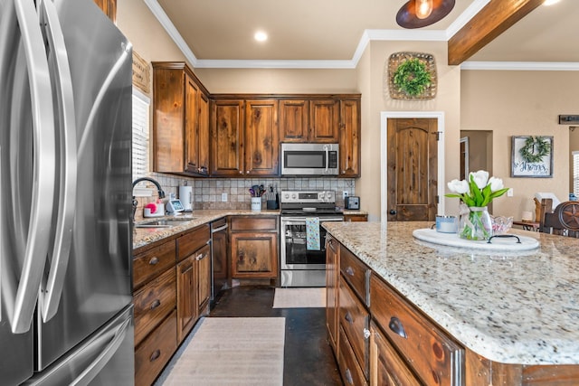 kitchen with stainless steel appliances, a center island, light stone countertops, decorative backsplash, and sink