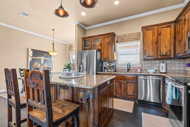 kitchen with stainless steel appliances, decorative light fixtures, a center island, and sink