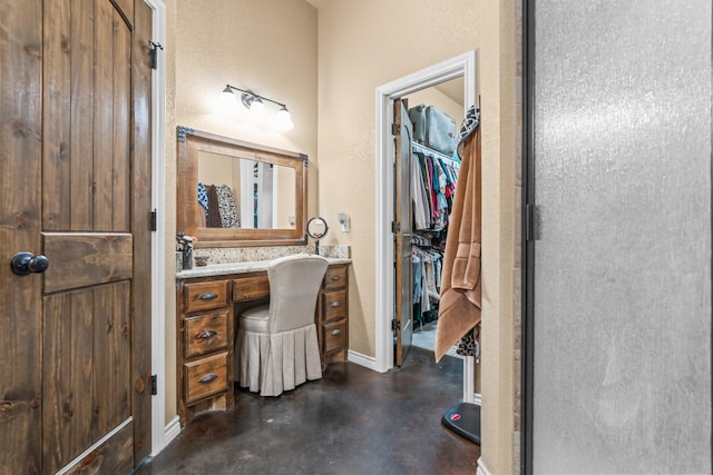 bathroom featuring concrete floors, a shower with shower door, and vanity