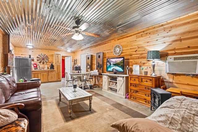 living room with a wall unit AC, wooden walls, sink, and ceiling fan