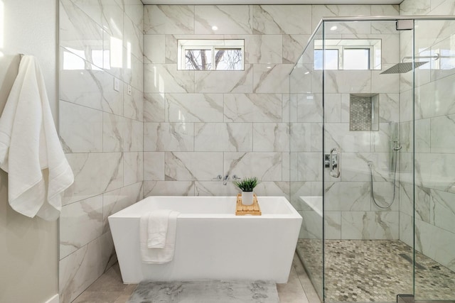 bathroom featuring independent shower and bath and a wealth of natural light