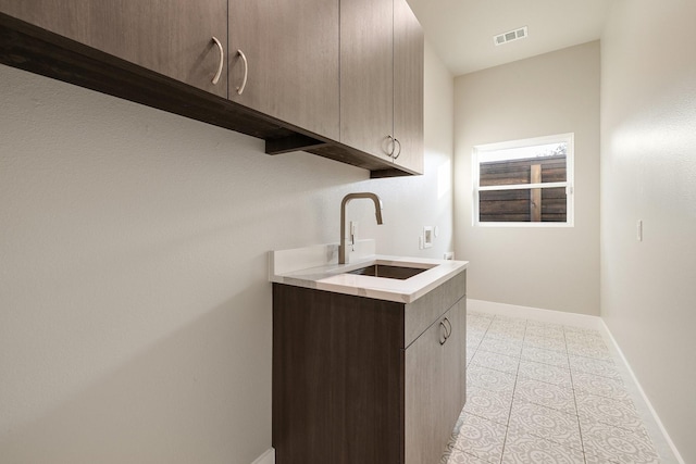 laundry room with cabinets, hookup for a washing machine, and sink